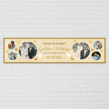 A personalized horizontal banner for a 50th wedding anniversary, featuring circular photo frames, gold script text, and small gold hearts on a cream background, mounted on a white brick wall.