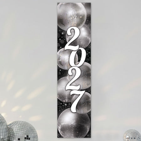 A vertical rectangular wall art print featuring the year '2027' in large white script over a black background with mirrored disco ball illustrations. The print is shown hanging against a light gray wall with decorative disco balls at the bottom corners.