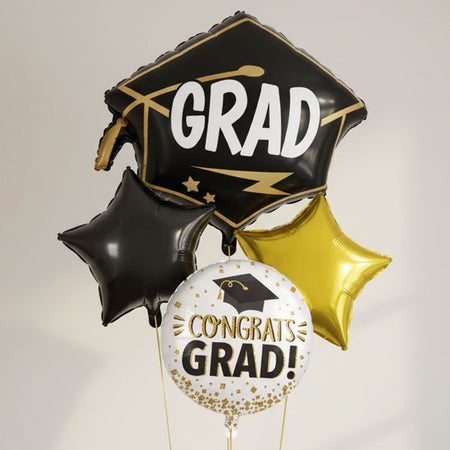 Graduation-themed balloons with 'GRAD' and 'Congrats Grad!' text on a neutral background