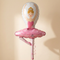 Ballerina balloon with pink curling ribbon hanging behind it, against a softly lit cream background