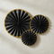 Black and Gold Paper Fan Decorations on Textured Wall