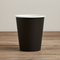 Black paper cup on wood table minimal background
