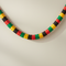 Black yellow green red tissue paper garland draped on wall