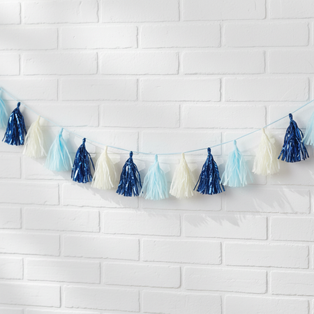 Blue and white tassel garland on a white brick wall