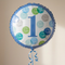 Blue first birthday balloon floating with blue curling ribbon against a neutral background with soft light and shade