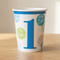 Blue number 1 birthday cup on a wood table with a neutral background and soft light and shade, square format