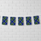 Blue tartan bunting across a white brick wall