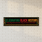Celebrating Black History banner on white brick wall
