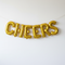 CHEERS Gold Foil Balloons Hanging Like Bunting on White Wall