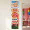Circus banner on a neutral wall beside an open doorway into a circus-themed party, with the banner in focus in square format