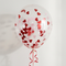 Clear red-heart balloon floating with red curling ribbon against an off-white background with soft light and shade, in square format
