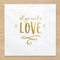 Close-up All You Need Is Love napkin on a wood surface, retaining the overhead perspective and square format