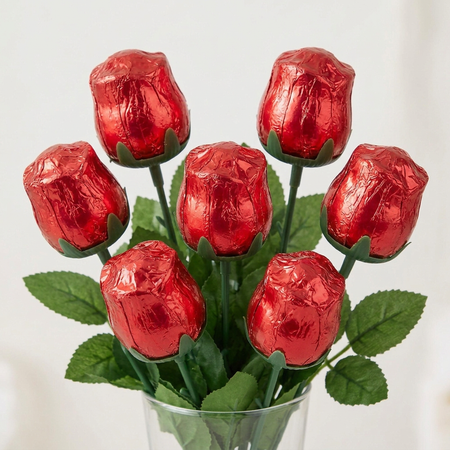 Close-up bouquet of six foil-wrapped chocolate roses in a vase