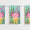 Close-up of axolotl bunting pennants hanging from clear ribbon tape on a white wall, square format