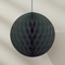 Close-up of one black tissue paper ball against a neutral wall