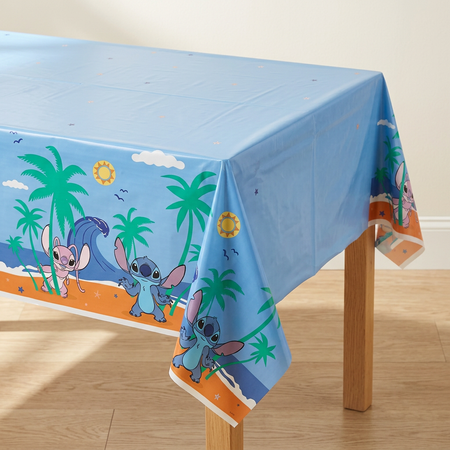 Close-up of the tablecloth draped over a wooden table corner, with a wood floor and neutral background in square format