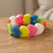 Close-up square heart bracelet image on a wooden table with a neutral background