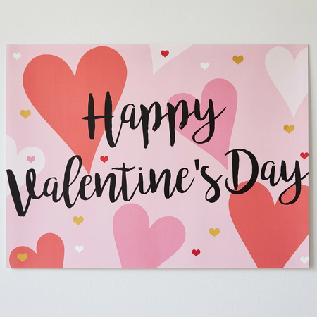 Close-up Valentine’s Day poster on a white wall with soft light and shade
