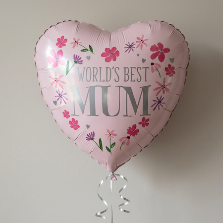 Close-up World’s Best Mum balloon floating with silver curling ribbon against a softly shaded neutral background, in square format
