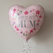 Close-up World’s Best Mum balloon floating with silver curling ribbon against a softly shaded neutral background, in square format