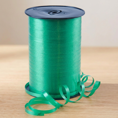Emerald green curling ribbon reel on the matching wooden tabletop with a neutral background and soft lighting, in square format