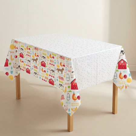 Farm-print tablecloth on a wooden-legged table against a neutral background, close up in square format