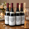 Four matching bottles on a wooden table in a softly lit romantic setting, in square format