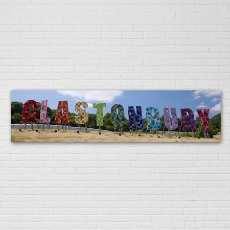 Glastonbury Sign Banner on White Brick Wall