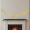 Gold glitter Merry Christmas bunting above a Christmas fireplace