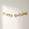 Gold Happy Birthday banner on one continuous white string against a white wall with soft light and shade, in square format
