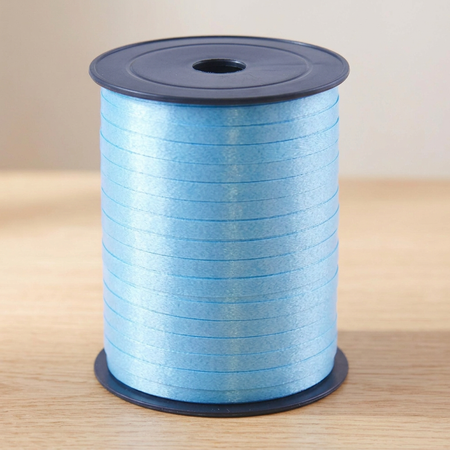 Light blue curling ribbon reel on the matching wooden tabletop with a neutral background and soft lighting, in square format