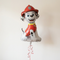 Marshall balloon floating with red curling ribbon against a neutral wall, in square format