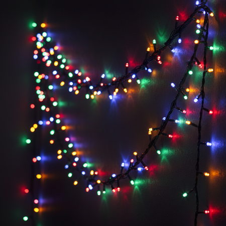 Multicoloured LED Fairy Lights Strung on Wall in Dim Light