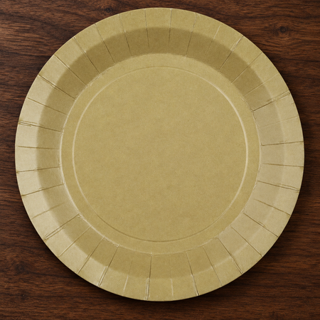 Natural-coloured plate viewed from above on a dark wood table, close up in square format