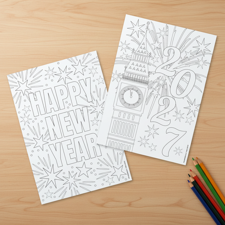 New Year colouring sheets on a wood table with pencils