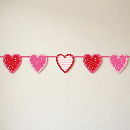 Original five-heart bunting against a cream wall with light and shade, in square format