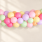 Pastel balloon arch with a softly lit warm off-white background