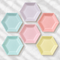 Pastel hexagonal plates on white tablecloth from above