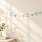 Pastel star bunting on cream wall with light and shade