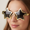 Person Wearing Gold Star Glasses Close Up on Neutral Background