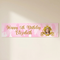 Personalised princess birthday banner on a cream wall with soft light and shade, in square format