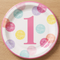 Pink number 1 birthday plate on a wood tabletop, shown close up from above in square format