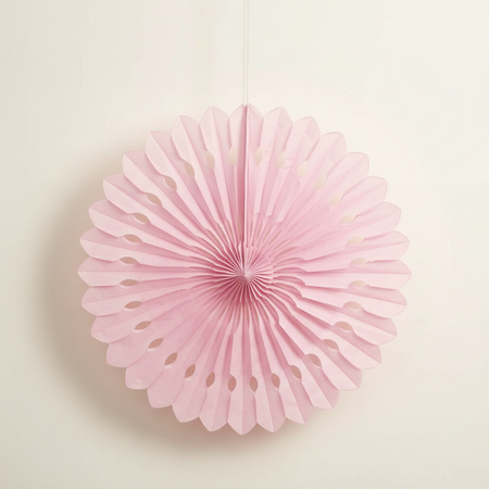 Pink Tissue Fan Hanging Against Neutral Wall