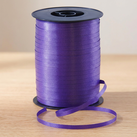 Purple curling ribbon reel on the matching wooden tabletop with a neutral background and soft lighting, in square format