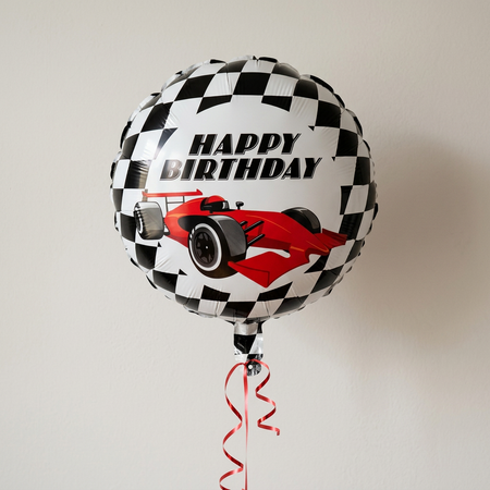 Racing birthday balloon floating with red curling ribbon against a softly lit neutral wall, close up in square format
