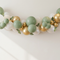 Realistic white, sage green and gold balloon arch with green eucalyptus foliage