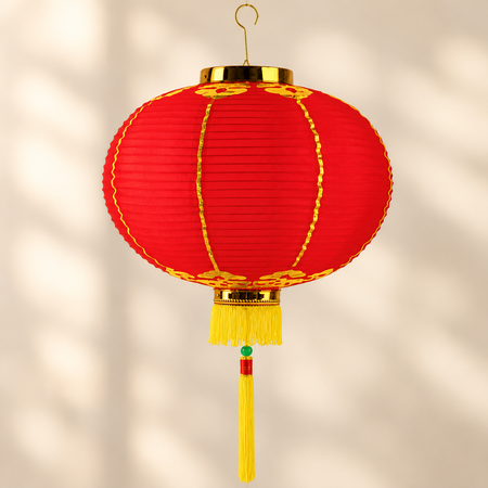 Red Chinese fabric lantern hanging from its gold hook against a neutral background, square format