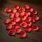Red Silk Rose Petals Scattered on Table