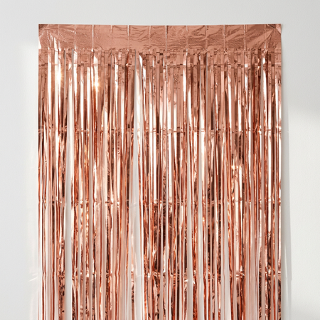 Rose gold foil curtain close up against a white wall with natural light and shade, in square format