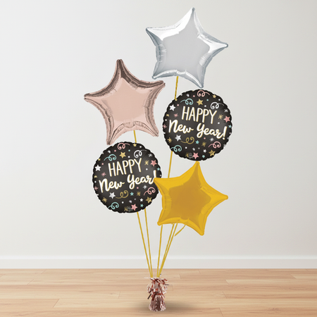 Rose gold New Year balloon bouquet on a wood floor